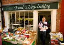 A shopper buys some figs from one of the many traditional shops amidst Ludlow's narrow streets.